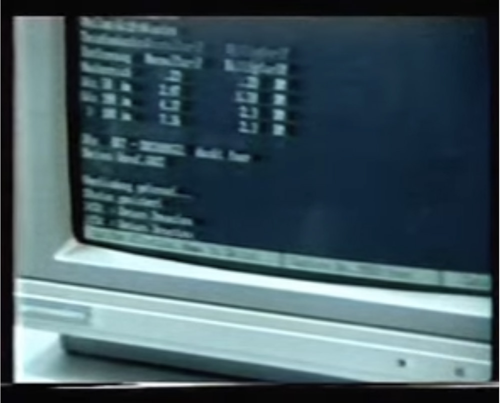 Ausschnitt eines alten Computers. Der Bildschirm zeigt Codeschrift auf schwarzem Hintergrund.