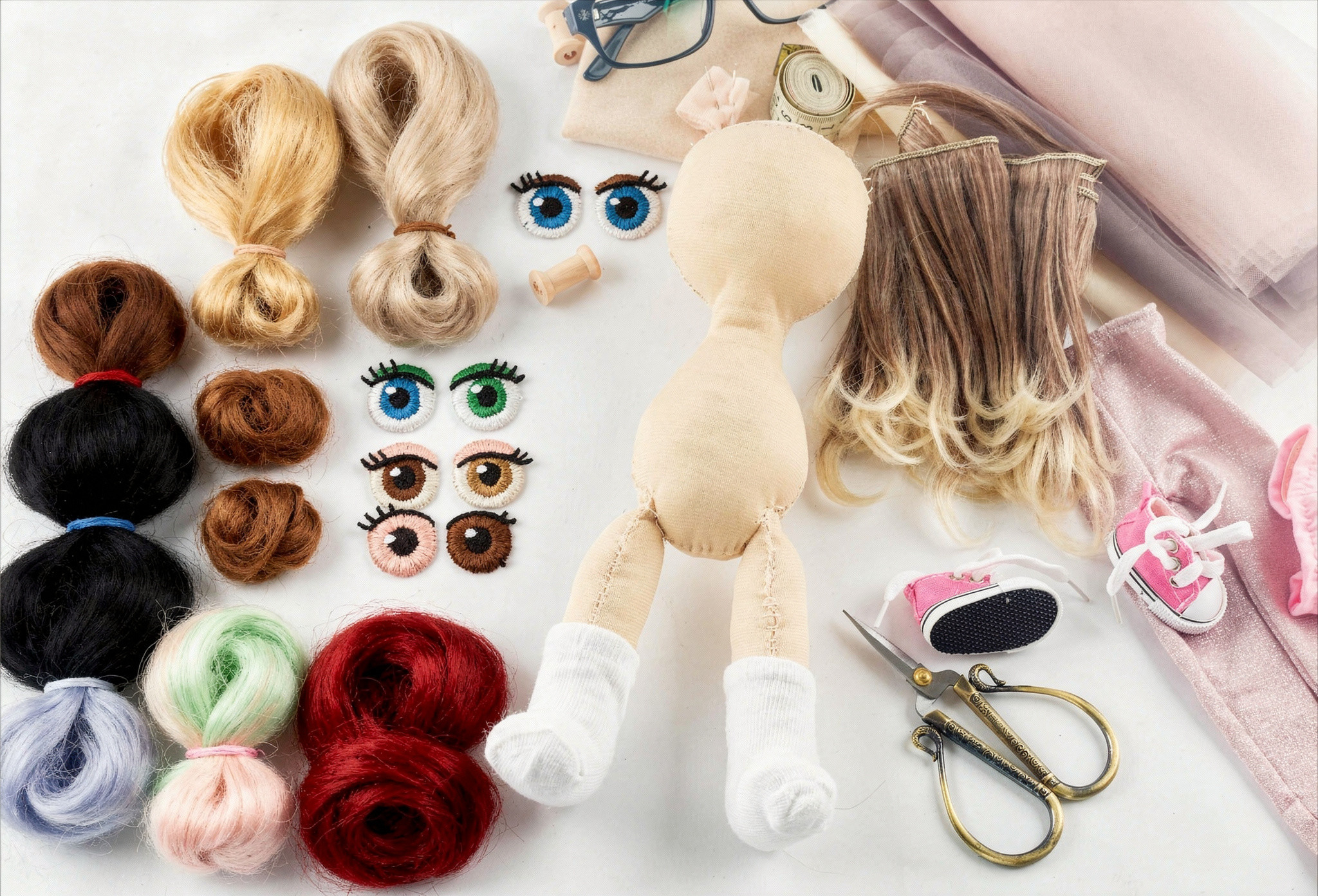 Puppe mit Stoffkörper und weißen Socken umgeben von verschiedenen Haarsträhnen, bunten Puppenaugen, einer Schere, kleinen Schuhen und Nähzubehör auf hellem Untergrund